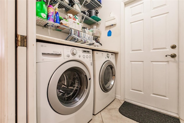 washroom with washing machine and clothes dryer and light tile patterned floors