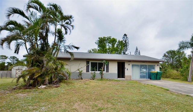 single story home with a storage unit and a front lawn