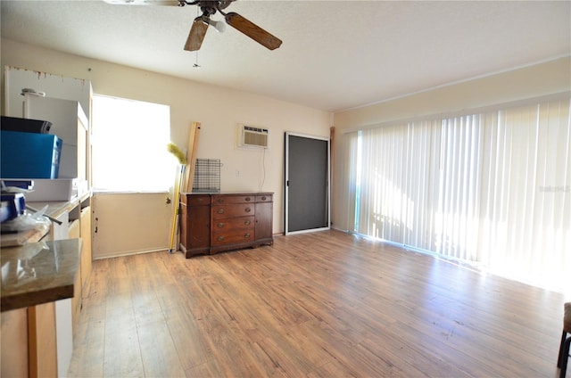 unfurnished living room with light hardwood / wood-style floors, a wall mounted AC, and ceiling fan