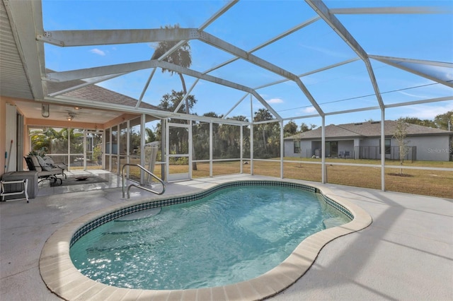 view of pool featuring a yard, a patio, ceiling fan, and a lanai