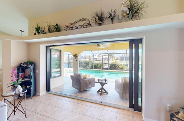 entryway with tile patterned floors, ceiling fan, and a high ceiling