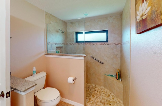 bathroom featuring a tile shower and toilet