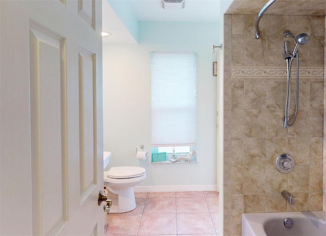 bathroom with tile patterned flooring, toilet, and tiled shower / bath