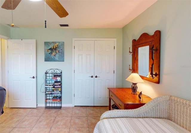 bedroom featuring light tile patterned floors, a closet, and ceiling fan