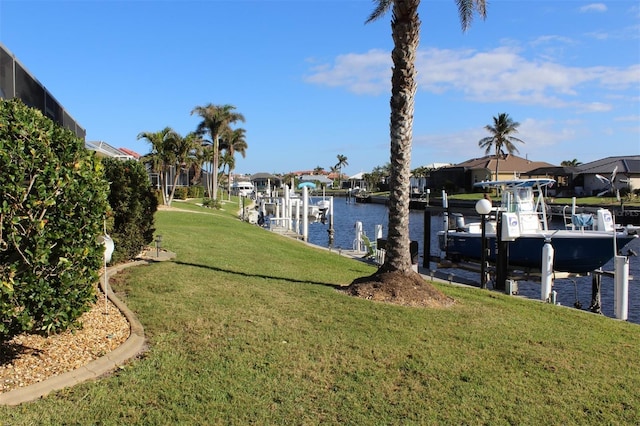 dock area featuring a lawn and a water view