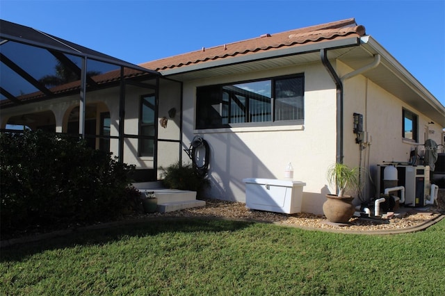 rear view of property featuring a lanai and a yard