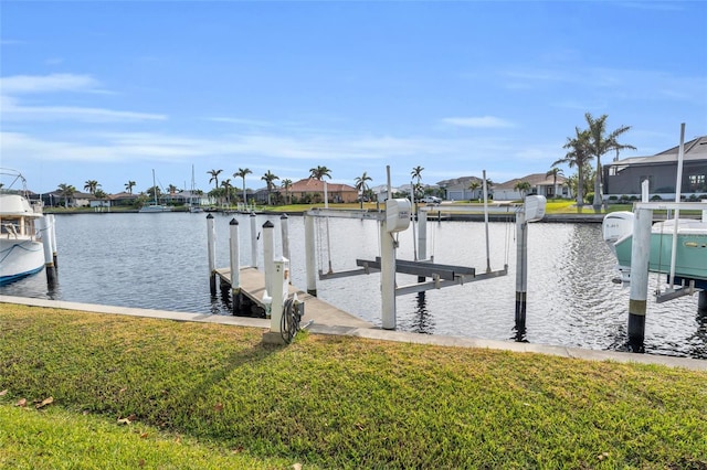 dock area featuring a lawn and a water view