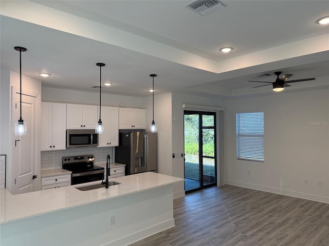 kitchen with sink, dark hardwood / wood-style flooring, backsplash, white cabinets, and appliances with stainless steel finishes