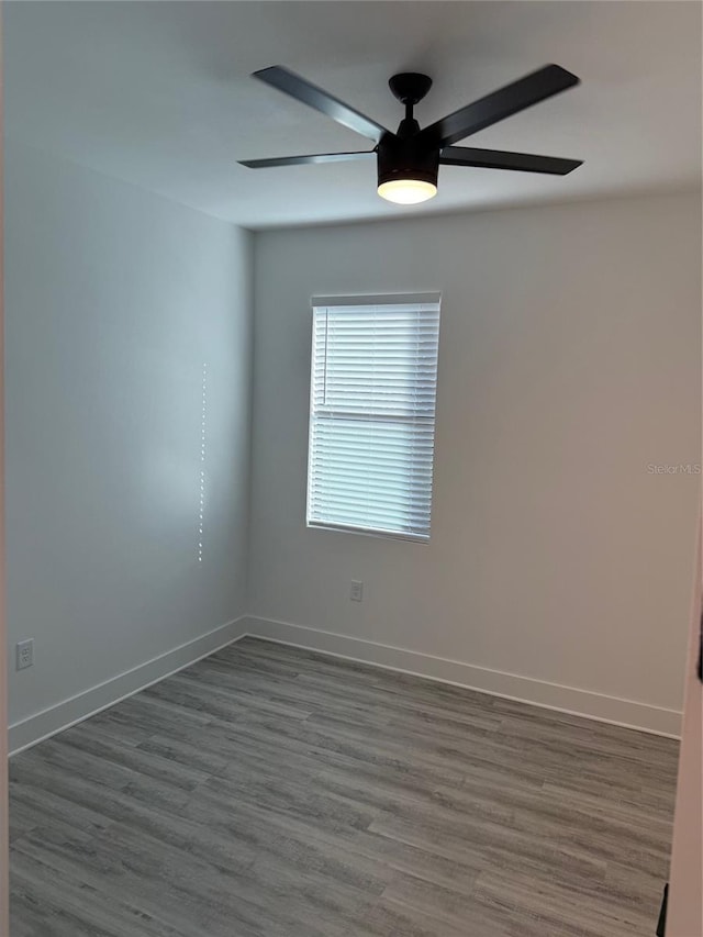 unfurnished room with dark hardwood / wood-style flooring and ceiling fan