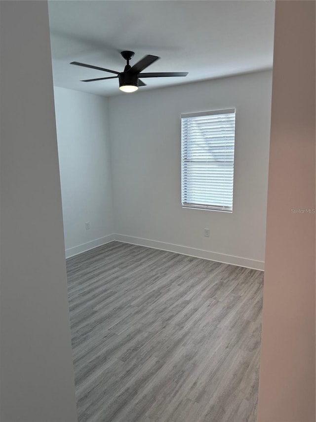 spare room featuring light hardwood / wood-style flooring and ceiling fan