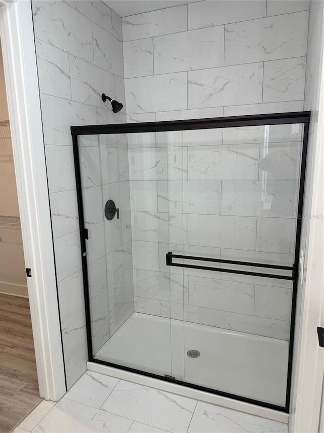 bathroom featuring hardwood / wood-style flooring and an enclosed shower