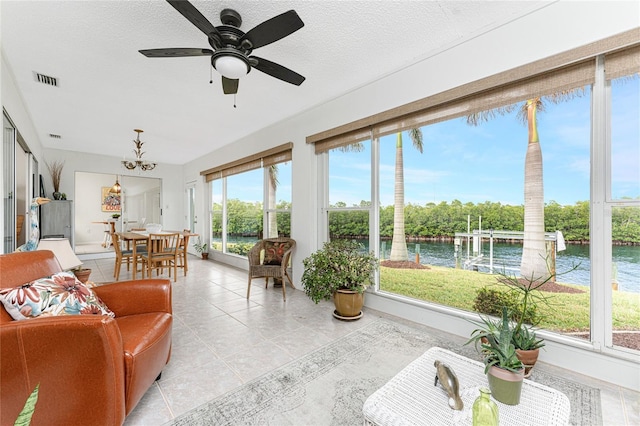 sunroom featuring ceiling fan with notable chandelier and a water view