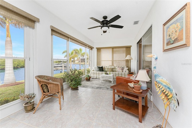 sunroom featuring a water view and ceiling fan