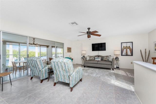 living room featuring ceiling fan and a textured ceiling