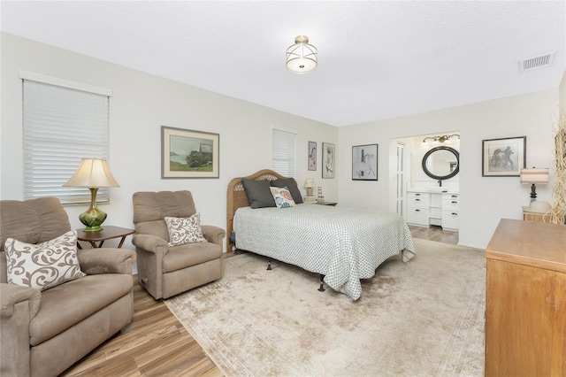 bedroom with a textured ceiling and light wood-type flooring