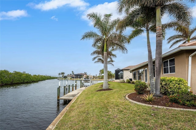 dock area with a lawn and a water view