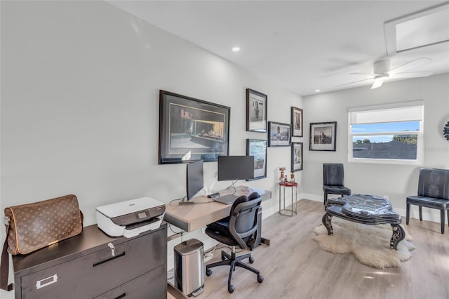 home office with light hardwood / wood-style floors and ceiling fan