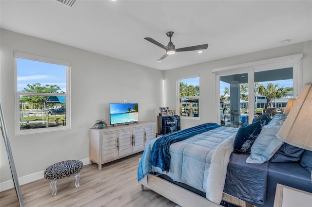 bedroom with ceiling fan, french doors, and light hardwood / wood-style floors