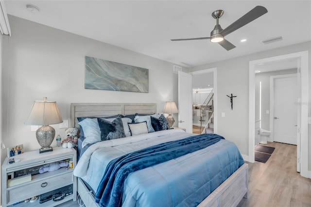 bedroom with light wood-type flooring, ensuite bath, and ceiling fan