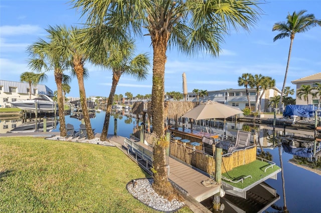 view of dock featuring a lawn and a water view