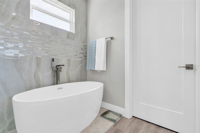 bathroom with a tub and hardwood / wood-style flooring