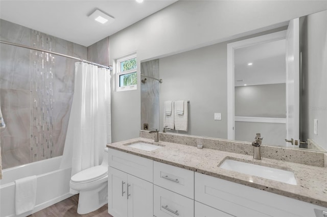 full bathroom with hardwood / wood-style floors, vanity, toilet, and shower / tub combo with curtain