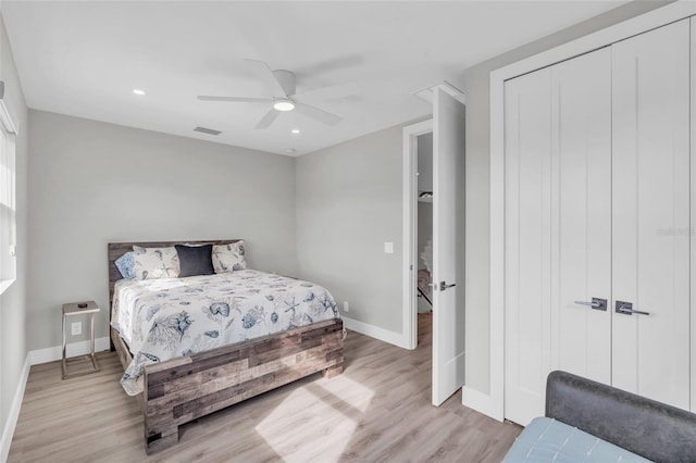 bedroom with a closet, light hardwood / wood-style floors, and ceiling fan