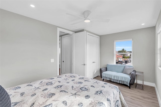 bedroom with a closet, ceiling fan, and light hardwood / wood-style flooring