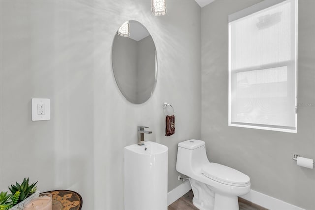 bathroom featuring wood-type flooring and toilet