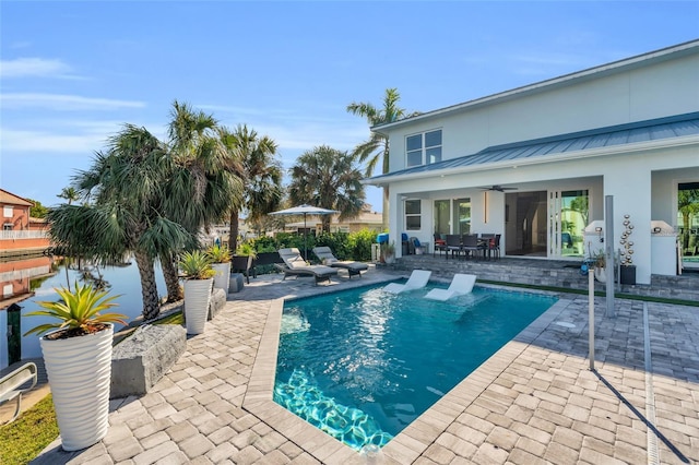 view of swimming pool featuring ceiling fan and a patio area