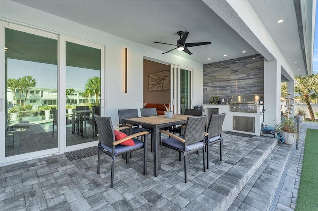 view of patio with area for grilling, ceiling fan, and an outdoor kitchen