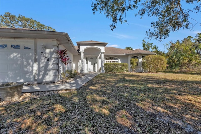 single story home with a garage and a front lawn