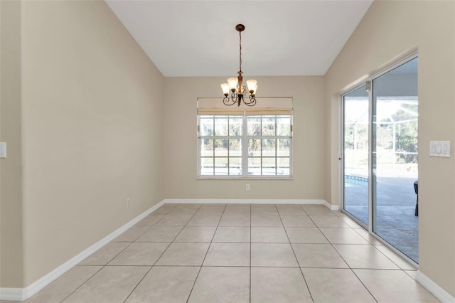 unfurnished dining area featuring a chandelier, a healthy amount of sunlight, light tile patterned flooring, and vaulted ceiling