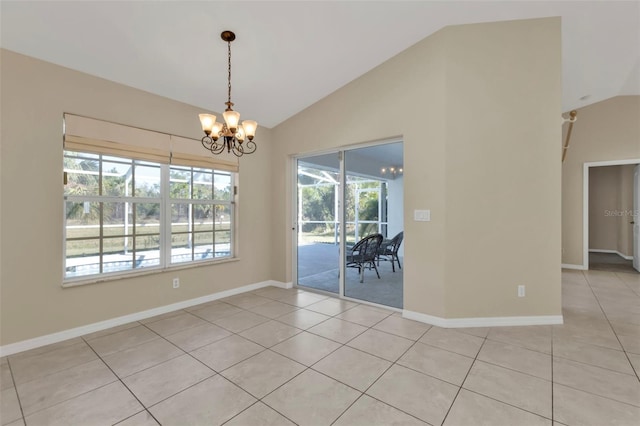 tiled spare room featuring a wealth of natural light, a chandelier, and vaulted ceiling