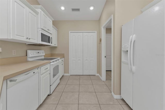 kitchen with white cabinets, light tile patterned flooring, and white appliances