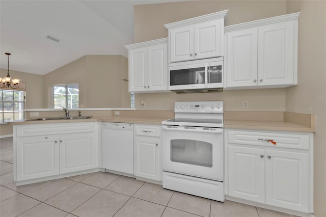 kitchen with sink, a chandelier, lofted ceiling, white appliances, and light tile patterned floors