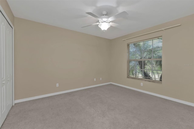 carpeted spare room with ceiling fan