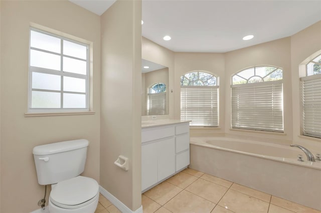 bathroom featuring a washtub, vanity, tile patterned flooring, and toilet