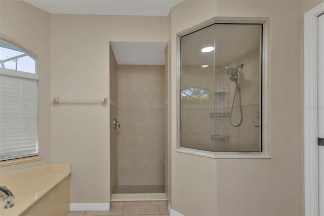 bathroom featuring tile patterned floors and a tile shower