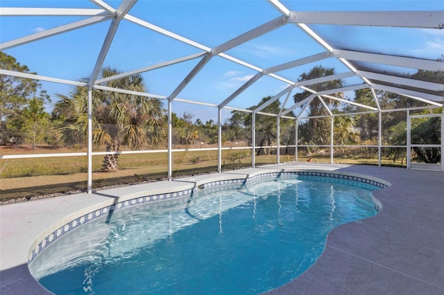 view of swimming pool with glass enclosure and a patio area