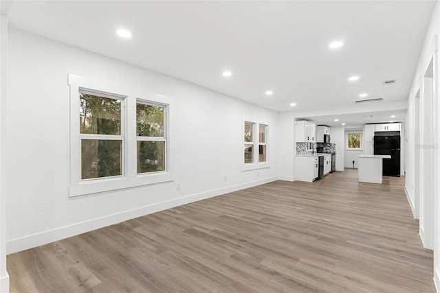 unfurnished living room featuring light hardwood / wood-style floors and sink