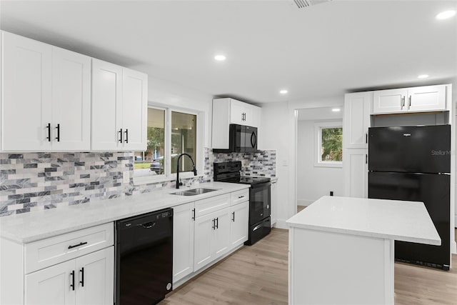 kitchen with white cabinetry, a center island, and black appliances