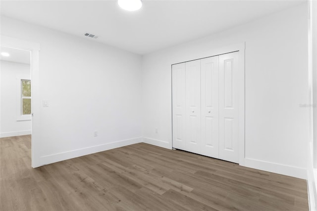 unfurnished bedroom featuring a closet and hardwood / wood-style flooring