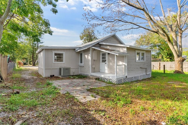 view of front of property with a front lawn, a patio area, and cooling unit