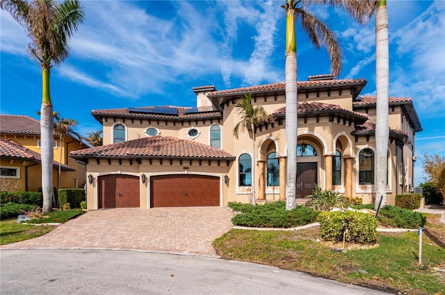 mediterranean / spanish-style house featuring solar panels