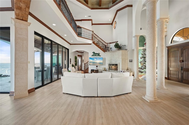 living room with a towering ceiling, decorative columns, and a healthy amount of sunlight