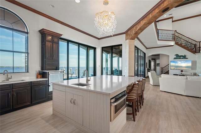 kitchen with appliances with stainless steel finishes, a center island with sink, a notable chandelier, and sink