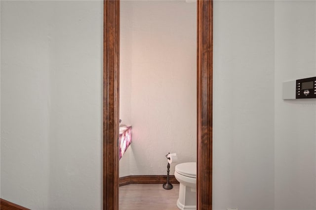 bathroom featuring hardwood / wood-style flooring and toilet