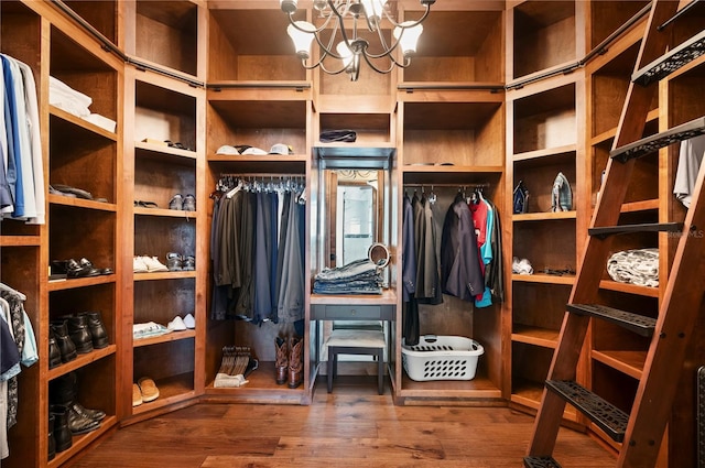 spacious closet with hardwood / wood-style floors and a notable chandelier