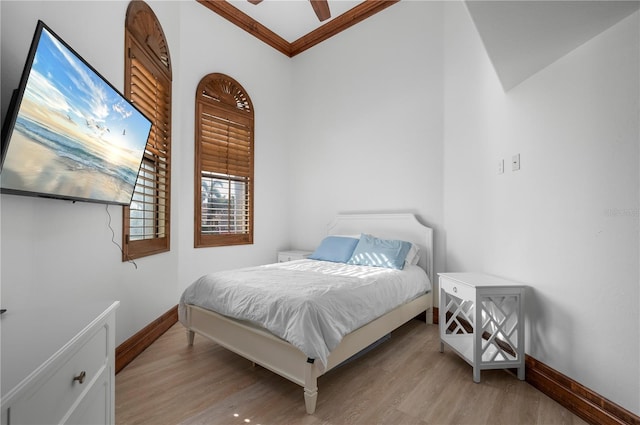 bedroom featuring ceiling fan, ornamental molding, and light wood-type flooring